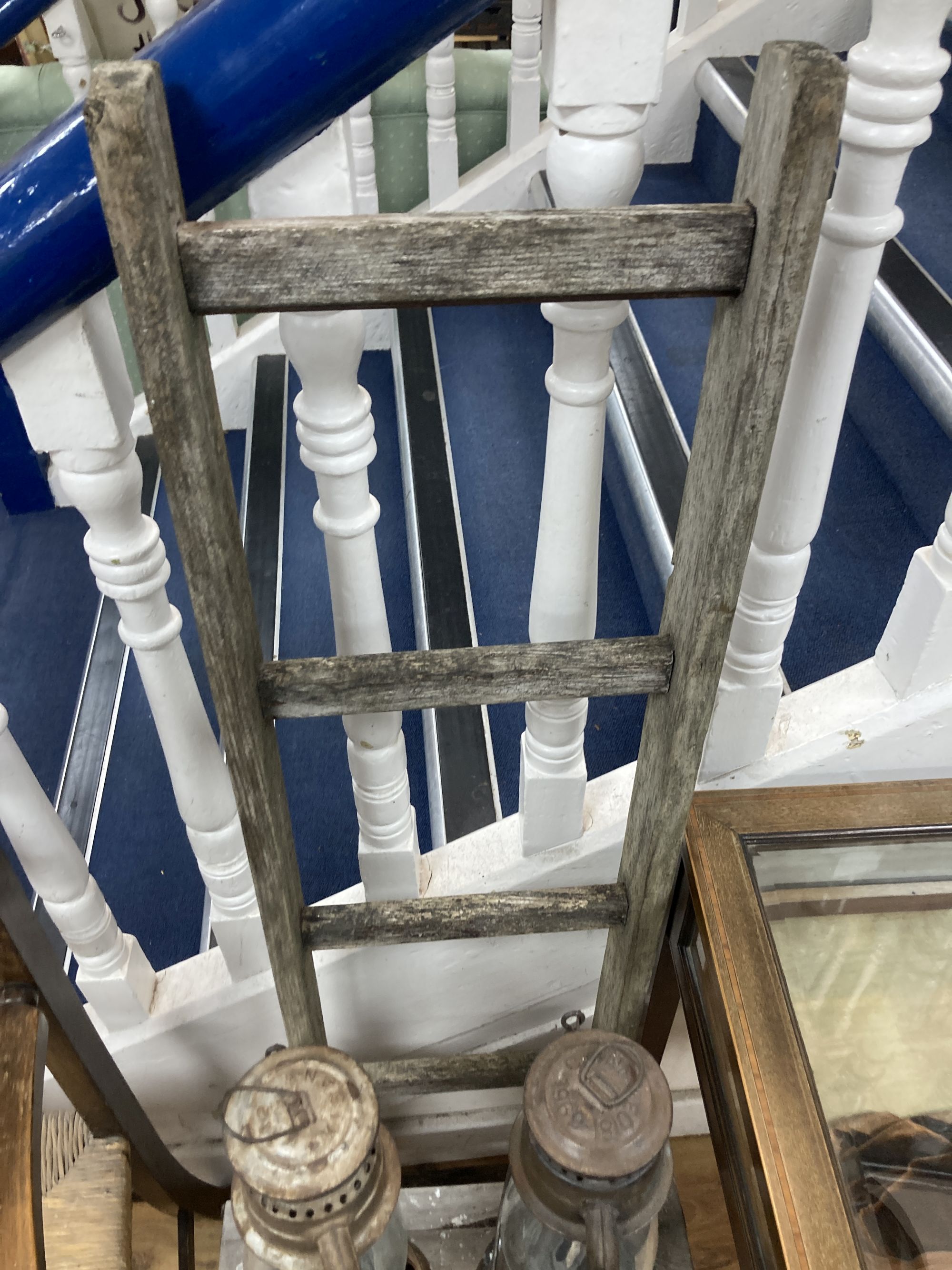 A rush seated beech elbow chair, a vintage five tread step ladder, a similar pine step stool and two oil lamps